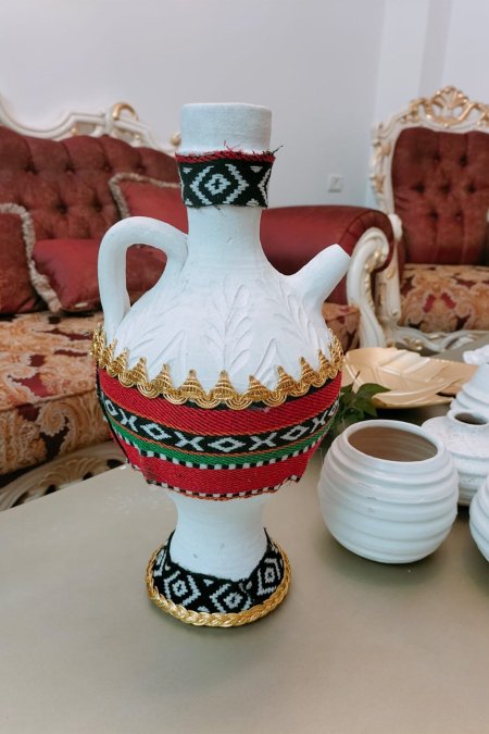 إبريق فخاري أبيض مزين بالنقوش البدوية